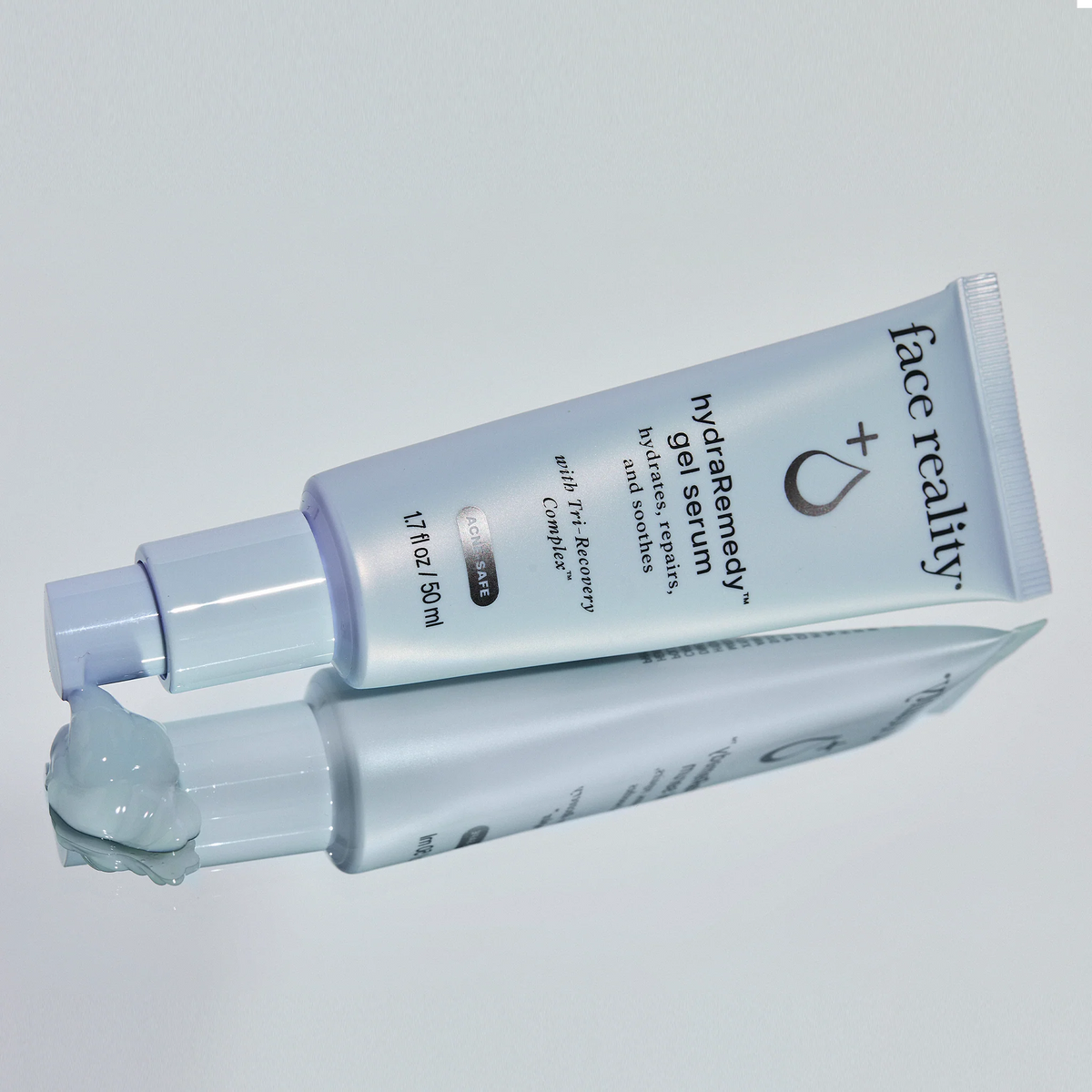 Skincare gel tube with 'face reality' branding on a light gray background