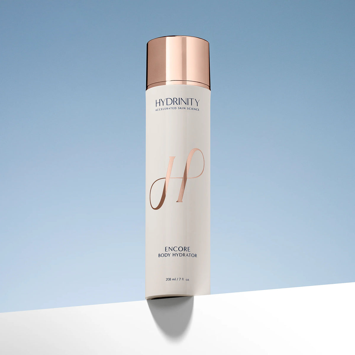 Hydrating lotion bottle with rose gold cap and branding on a light blue background