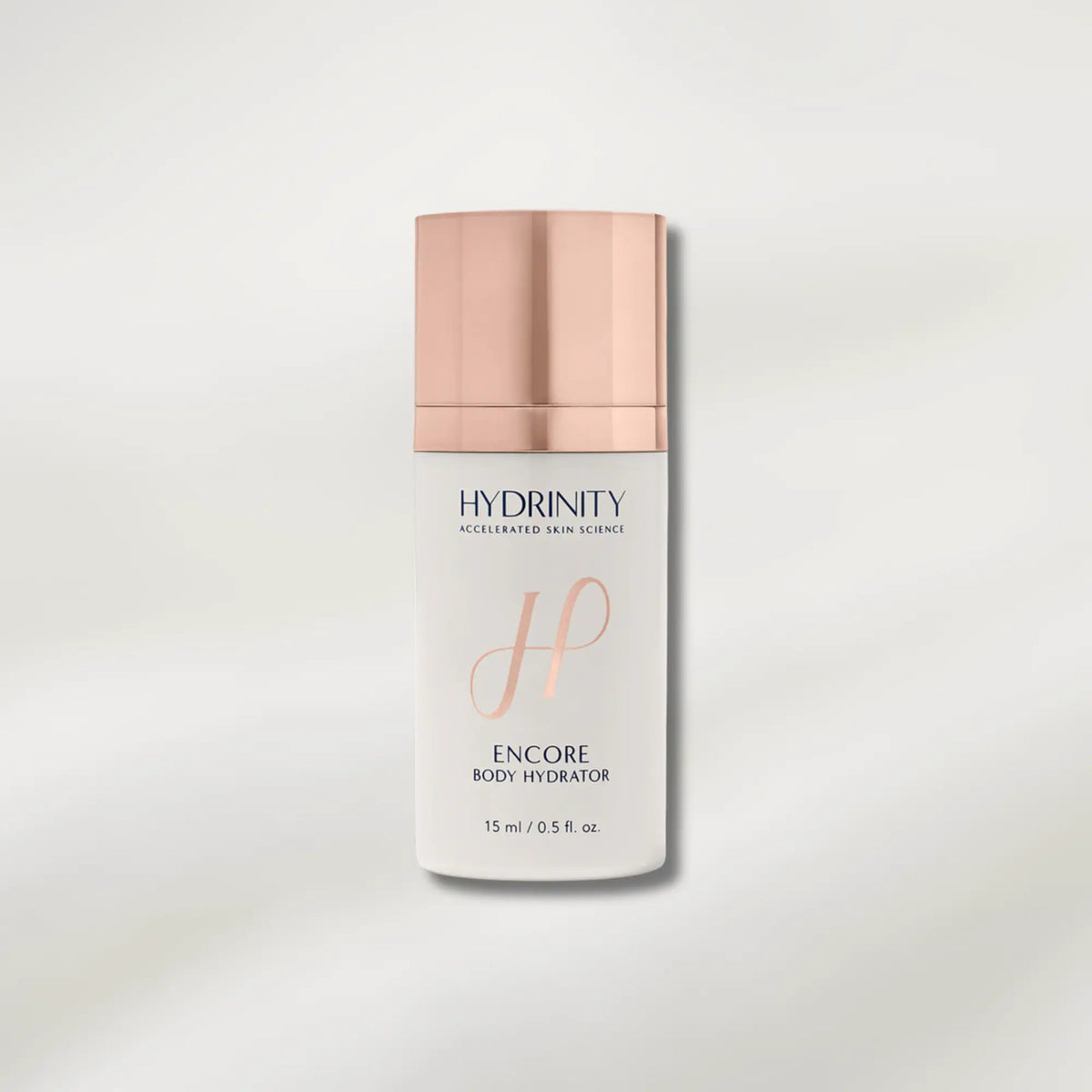 Body hydrator bottle with rose gold cap and branding on a light gray background