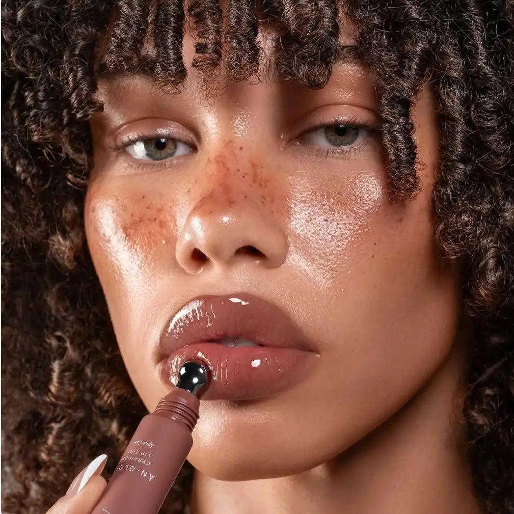Close-up of a person applying lip gloss with a brush