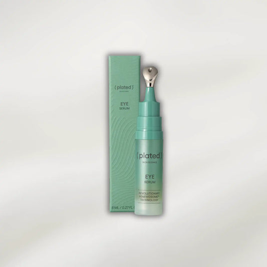 Plated eye serum bottle and packaging on a light gray background