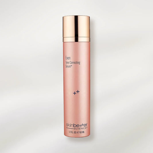Skincare serum bottle with gold cap on a light gray background
