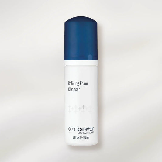 Skincare bottle labeled 'Refining Foam Cleanser' with blue cap on a white background