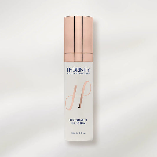 Hydrinity Restorative HA Serum bottle with rose gold cap on a white background